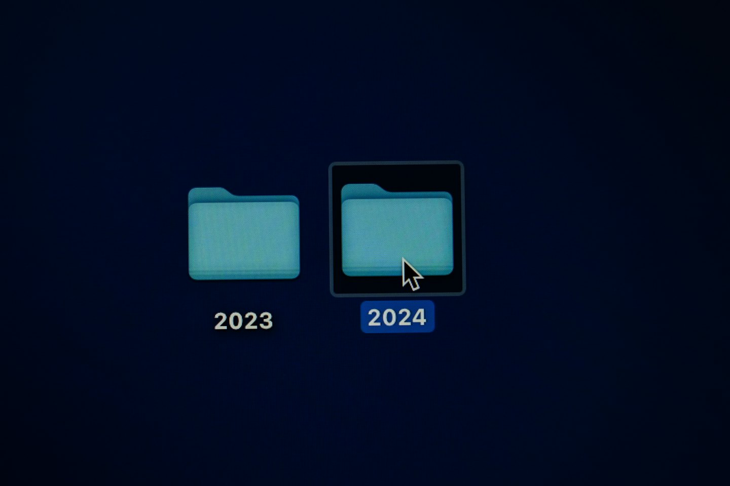 Computer screen showing 2023 and 2024 digital folders with cursor.